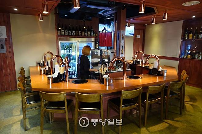 카운터형 테이블 15석에 화구 7개를 갖춘 매장 내부.