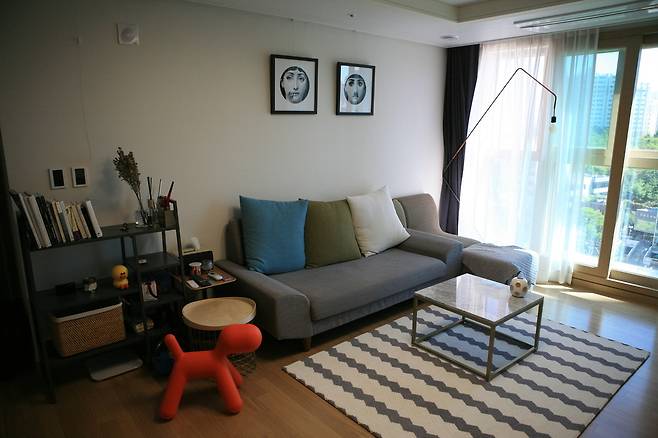 소파 뒤 벽의 액자를 인테리어 소품으로 활용한 서울 금호동 주성범씨 아파트의 거실. 이정국 기자