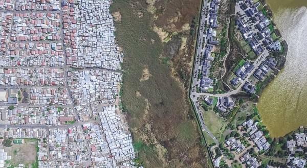 중앙의 녹지가 마치 장벽처럼 부촌과 빈민촌을 갈라놨다. 20여년 전에 사라진 남아프리카공화국 인종차별 정책의 잔재다. [사진=남아공 사진작가 조니 밀러(Johnny Miller) 페이스북]