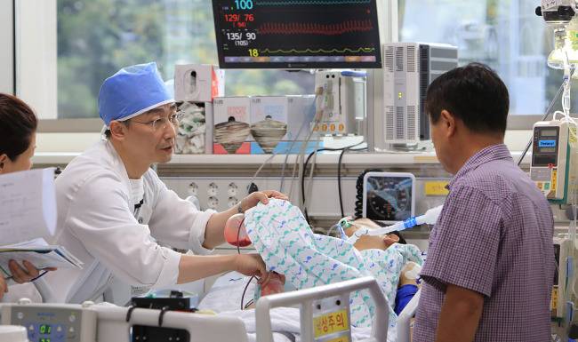 이국종 교수가 환자 보호자에게 경과를 설명하고 있다. [박해윤 기자]