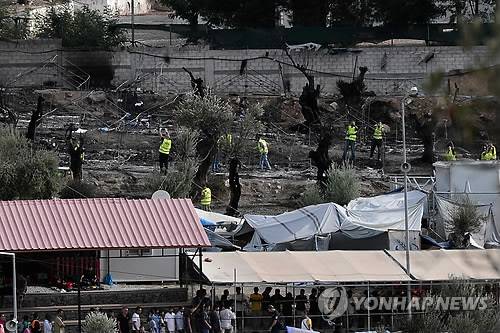 그리스 난민캠프 화재 현장 정리작업     (레스보스섬<그리스> AFP=연합뉴스) 그리스 레스보스섬의 한 난민 캠프에서 19일(현지시간) 방화로 추정되는 불이 나 난민 캠프 하나가 전소됐다. 사상자는 없었으나 수용된 난민 최대 4천여 명이 한꺼번에 탈출하며 한밤에 아비규환이 벌어졌다.      사진은 20일 레스보스섬의 모리아 난민 캠프에서 캠프 직원들이 전날 밤 화재가 발생한 현장을 정리하는 모습. 사진 아래쪽에는 난민들이 식량을 배급받기 위해 줄지어 서 있는 모습.