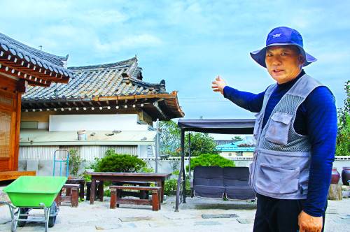 경북 경주시 선도동 마을에 25일 지진피해 복구 자원봉사를 나온 한규석씨가 보수작업이 진행 중인 기와지붕을 가리키고 있다. 전남 영암군에서 23년 동안 와공(기와전문가) 일을 한 한씨는 이틀째 경주에서 자원봉사 활동을 하고 있다.