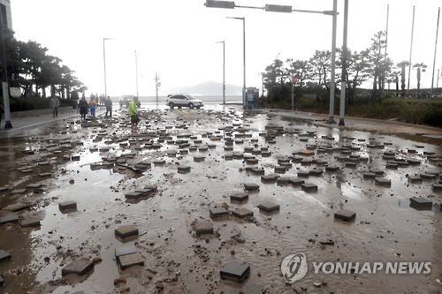 (부산=연합뉴스) 조정호 기자 = 5일  제18호 태풍 '차바'(CHABA)가 몰고 온 파도에 부산 해운대구 마린시티 보도블럭이 도로로 밀려와 엉망이 됐다. 2016.10.5