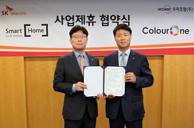 조영훈 SK텔레콤 홉사업본부장(왼쪽)과 최규성 우리조명 대표가 스마트홈 서비스와 연동하는 IoT 조명 개발을 위한 협약을 체결했다.
