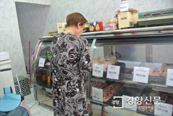 9월9일 브라질 상파울루의 닭고기 정육점 포피뇨 프랑고에 장을 보러 나온 한 할머니가 닭고기를 주의깊게 고르고 있다. 이 할머니는 스테이크를 해먹겠다며 닭다리살을 구입했고, 계란도 한 판 사갔다.