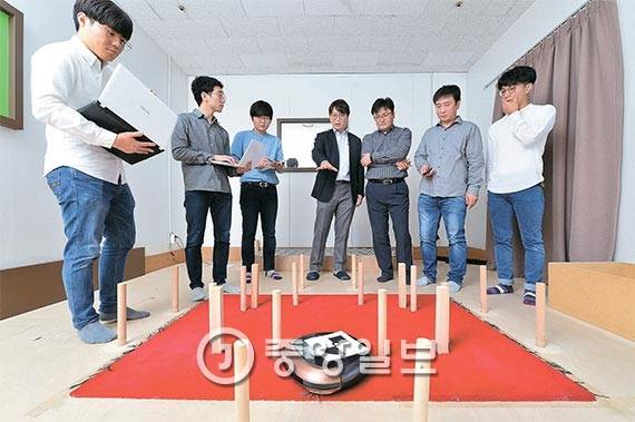 서울 가산디지털단지에 있는 한 기업 에서 임성수 경희대 기계공학과 교수(왼쪽 넷째)와 연구팀이 로봇청소기의 성능을 시험하고 있다. 말뚝 형태의 장애물을 피해 움직이는지 확인하는 것이다. [사진 우상조 기자]