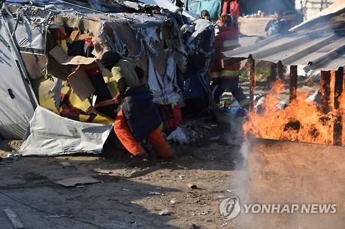 (칼레 AFP=연합뉴스) 프랑스 정부가 25일(현지시간) 칼레 난민촌 철거 작업을 시작한 가운데 일부 난민이 철거에 반대하며 가건물에 불을 질렀다. 2016.10.25