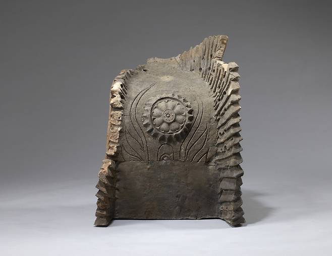 왕흥사터 동승방터 남쪽에서 나온 백제 치미의 측면. 음각된 불꽃모양 장식선 사이에 정교한 백제스타일 연꽃무늬가 돋을새김으로 올려졌다.