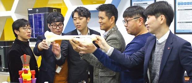 온새미로 창업협동조합에 참여한 조합원들이 모여 3D프린터로 만든 제품에 대한 설명을 듣고 있다. 왼쪽부터 박정민 한국산업기술대 컴퓨터공학과 교수, 강귀선 학생, 최근식 링크솔루션 대표, 박양일 이사장, 공성랑 해나소프트 대표, 정규민 패럴랙스 대표. 김낙훈 기자