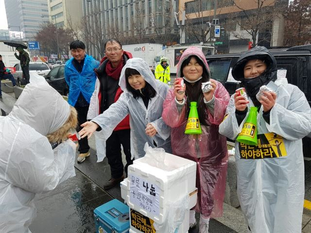 26일 오후 서울 광화문광장에서 시민들이 5차 촛불집회에 참가한 중ㆍ고교생들에게 주먹밥을 나눠주고 있다. 김정현 기자