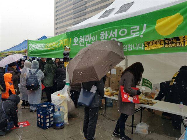 26일 오후 광화문광장에서 열린 5차 촛불집회를 앞두고 인터넷 커뮤니티 '82cook'의 회원들이 집회 참가자들에게 하야 커피를 나눠주고 있다. 박재현 기자