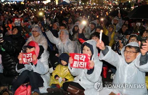 부산서 '대통령 즉각 퇴진' 촛불집회      (부산=연합뉴스) 김재홍 기자 = 26일 부산 부산진구 서면에서 열린 4차 시국대회에서 참가자들이 비가 내리는 궂은 날씨 속에서 대통령 퇴진을 요구하고 있다. 2016.11.26      pitbull@yna.co.kr