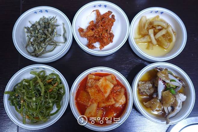‘수산항’의 밑반찬은 늘 6찬이다. 아래 왼쪽부터 시계방향으로 미역줄기볶음, 멸치볶음, 가자미식해, 양파장아찌, 꽃게장, 대구아가미깍두기. 밑반찬만 있어도 소주 1병은 거뜬하다.