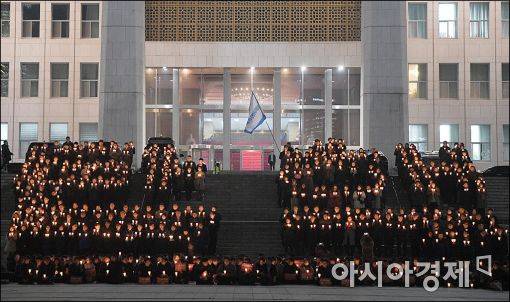 5일 더불어민주당이 국회 앞에서 박근혜 대통령의 퇴진을 요구하는 촛불을 들고 있다.