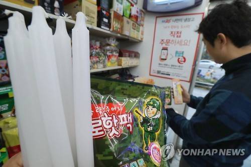 (서울=연합뉴스) 이상학 기자 = 주말 대규모 촛불집회를 하루 앞둔 25일 서울 광화문 광장 인근 편의점에서 한 시민이 양초와 핫팩 등을 고르고 있다. 2016.11.25 leesh@yna.co.kr