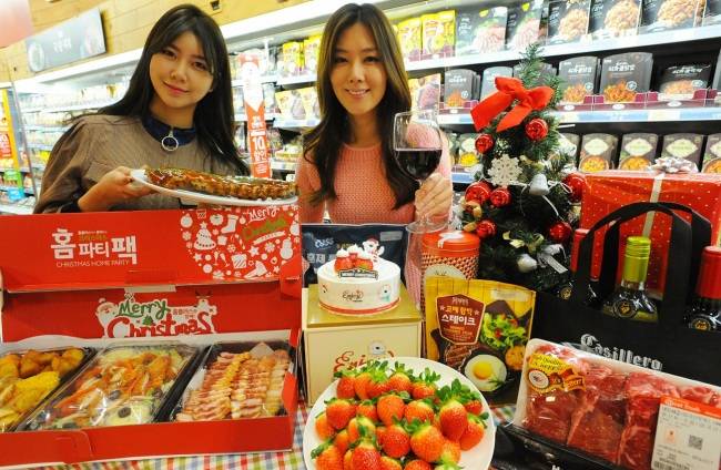 15일 홈플러스 강서점에서 모델이 크리스마스 홈파티 먹거리를 선보이는 모습. [사진=홈플러스 제공]