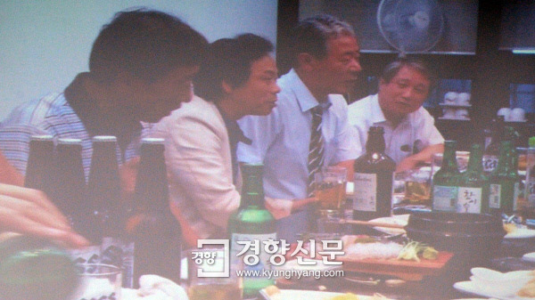 더불어민주당 박영선 의원이 22일 국회에서 열린 ‘박근혜·최순실 게이트’ 국정조사 청문회에서 위증 공모 의혹을 받고 있는 새누리당 이완영 의원(사진 왼쪽에서 두번째)과 최순실씨의 변호를 맡고 있는 이경재 변호사(오른쪽 두번째)가 함께 있는 시민 제보사진을 공개하고 있다. /강윤중 기자