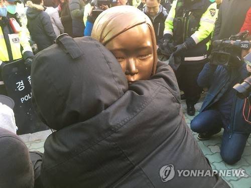 '울지마…' 소녀상 부둥켜 안은 시민 (부산=연합뉴스) 김선호 기자 = 28일 오후 부산 동구 초량동 일본영사관 앞 인도에서 '평화의 소녀상' 설치를 시도하며 연좌농성을 벌이던 '미래세대가 세우는 평화의 소녀상 추진위원회' 소속 회원이 관할구청인 동구청 직원들이 끌어내려고 시도하자 소녀상을 부둥켜 안고 있다.2016.12.28 wink@yna.co.kr