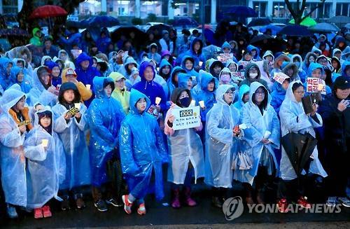 빗속 촛불집회      (제주=연합뉴스) 전지혜 기자 = 7일 오후 제주시청 민원실 앞에서 비가 내리는 날씨 속에 '박근혜 정권 퇴진 제주행동' 주최 12차 제주도민 촛불집회가 진행되고 있다. 2017.1.7      atoz@yna.co.kr