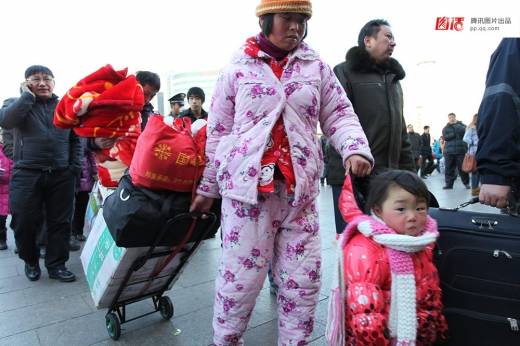 베이징에서 ‘잠옷차림’으로 아이와 함께 기차역에 들어서는 농민공. (사진=시각중국)