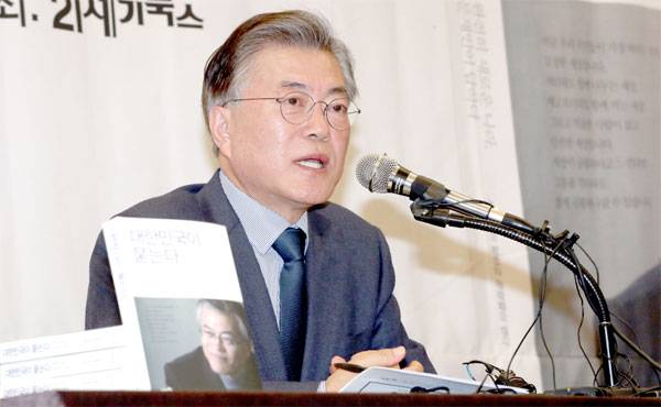 문재인 전 더불어민주당 대표가 17일 서울 중구 프레스센터에서 열린 출판기념 간담회에서 책을 들어 보이면서 취재진의 질문에 답하고 있다.  [김호영 기자]