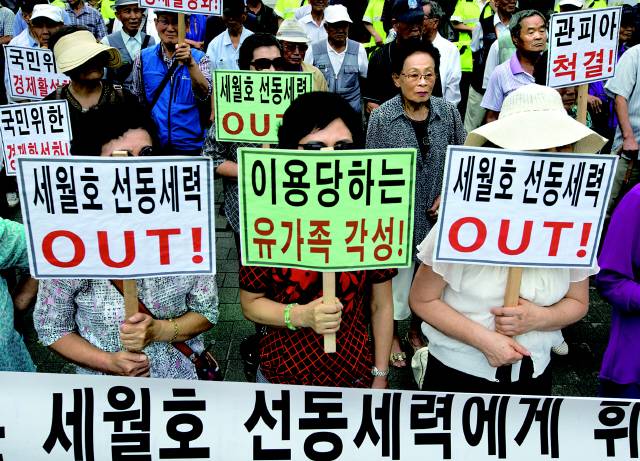 탈북난민인권연합과 나라사랑실천운동과 남침용땅굴을찾는사람들 그리고 대한민국어버이연합 등 시민·사회단체 회원들이 2015년 4월21일 오후 서울 종로구 청운효자동주민센터 앞에서 열린 '박근혜 대통령의 책임이행을 촉구하는 각계 대표 170인 기자회견' 앞에서 맞불 반대집회를 열고 있다. 맞불집회에 참가한 회원들은 이날 세월호 유가족이 선동세력에 의해 조종당하고 있다고 주장하며 이로 인해 나라 경제가 나락으로 떨어지고 있다고 주장했다. 또 세월호 사고는 해상교통사고에 불과하다며 단순 사고로 폄하하기도 했다. 김성광 기자 flysg2@hani.co.kr