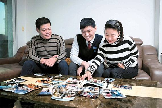 서울 영동고 2학년 황순영군(가운데)이 집에서 아버지·어머니와 가족여행 사진을 보며 담소를 하고 있다. 황군 같은 전교 1등 학생의 가정은 부모와 자녀 간에 대화가 많고 부모가 자녀를 자주 칭찬하는 게 특징이다. 전문가들에 따르면 부모에게 인정받는 자녀일수록 성취욕이 높고 실패를 잘 견뎌낸다고 한다. [사진 장진영 기자]