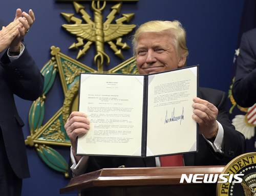 【워싱턴=AP/뉴시스】도널드 트럼프 미국 대통령이 27일(현지시간) 워싱턴 국방부 청사에서 미군 재건, 테러단체 관련국 출신 입국자 심사 강화 등의 내용이 담긴 행정명령서를 보여주고 있다. 2017.01.28