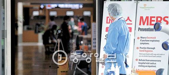 중동호흡기증후군(MERS·메르스)이 확산 중이던 2015년 7월 삼성서울병원. 내부 일부가 임시 폐쇄돼 한산한 모습을 보이고 있다. 마스크와 장갑을 낀 의료진이 입구를 지키고 있다. [중앙포토]