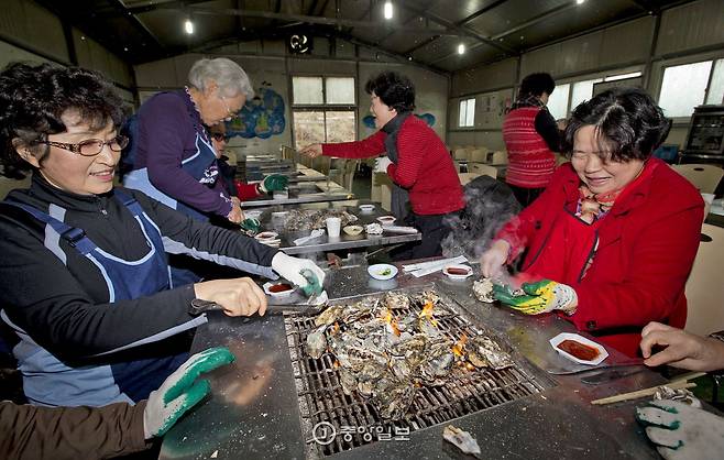 불을 쬐며 굴을 구워먹는 관광객의 모습.