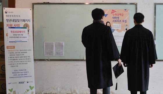 13일 오후 서울의 한 대학교에서 학위수여식을 마친 졸업생들이 텅빈 취업 게시판을 바라보고 있다. /사진=뉴스1