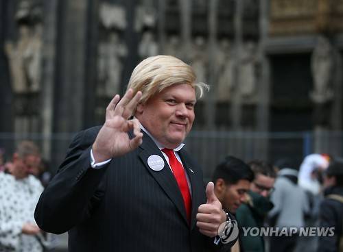 지난해 11월 독일 쾰른 카니발에서 도널드 트럼프 대통령의 복장을 흉내 낸 시민이 손을 흔들고 있다. [DPA=연합뉴스]