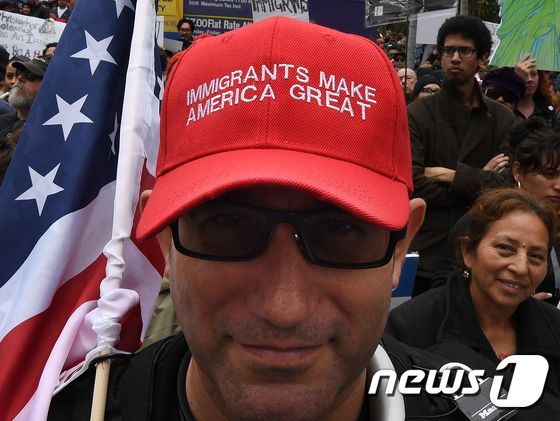 지난달 18일(현지시간) 트럼프 행정부의 반(反)이민 행정명령에 반대하는 시위대 참가자가 '이민자는 미국을 위대하게 만든다(Immigrants make America great)' 구호가 쓰인 모자를 쓴 모습. © AFP=뉴스1
