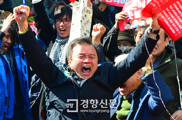 헌법재판소가 10일 박근혜 대통령 탄핵을 인용하자 인근에서 결정을 기다리던 탄핵 찬성 집회 참가자들이 ‘박근혜 탄핵, 촛불승리’라고 쓰인 손팻말을 높이 들며 환호하고 있다. 정지윤 기자 color@kyunghyang.com