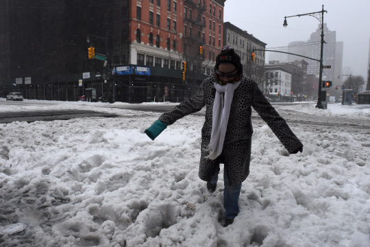 뉴욕시에서 한 여성이 폭설로 눈에 덮힌 길을 힘겹게 걷고 있다. /뉴욕=AFP연합뉴스