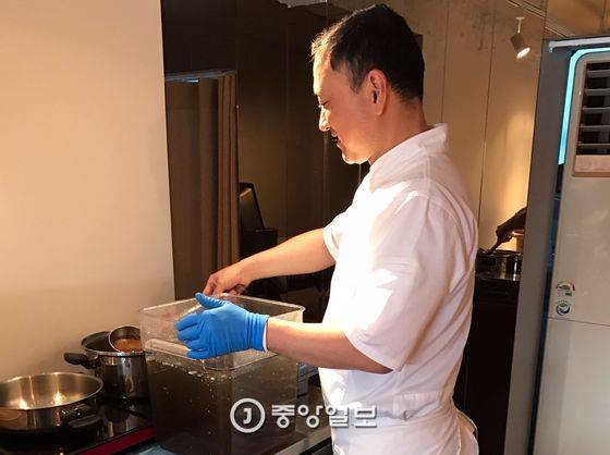 옥동식 셰프가 미리 끓여 냉장한 돼지곰탕 국물을 데우기 위해 인덕션에 올린 냄비에 옮겨 담고 있다. 이곳에서는 모든 조리를 가스를 쓰지 않고 전기로 한다.