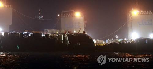 (진도 사진공동취재단=연합뉴스) 상하이샐비지 선원들이 23일 밤 침몰 해역인 전남 진도 동거차도 앞바다에서 세월호 야간 인양작업을 벌이고 있다.