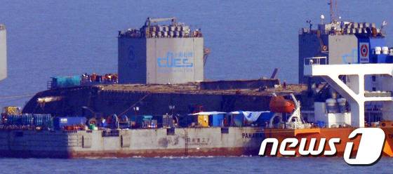 25일 오후 세월호 침몰 해역인 전남 진도군 동거차도 앞바다에서 중국 인양업체 상하이샐비지 관계자들이 반잠수식 선박에서 세월호 부양작업을 하고 있다. /뉴스1 © News1