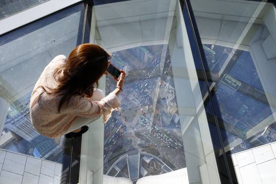 한 관람객이 118층 스카이데크 아래로 내려다 본 풍경을 사진에 담고 있다.