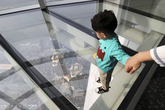 지상으로 부터 478m(118층) 높이에 시공된 '스카이데크' 전망대는 '가장 높은 유리 바닥 전망대'로 기네스 기록에 공식 인증됐다. 한 아이가 재촉하는 엄마의 손을 잡고 아래를 내려다 보고 있다.