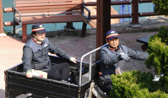 류지영(왼쪽) 기자가 홍도에서 16년째 집배원으로 활동하는 정대웅씨가 모는 삼륜오토바이에 타고 우편물을 배달하고 있다.