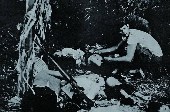 1968년 2월12일, 해병제2여단 1대대 1중대원들이 퐁니·퐁넛 마을을 다녀간 뒤 발견된 주검들을 미군 병사가 수습하고 있다. 당시 마을에 진입한 미군 상병 본이 촬영한 것이다.
