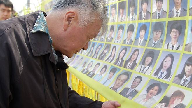 세월호 희생자의 사진을 바라보는 소설가 김훈, <한국방송> 제공