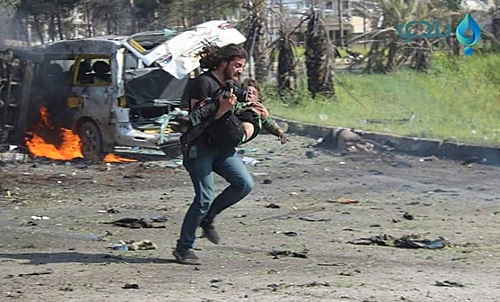【서울=뉴시스】시리아 인권 활동가이자 사진기자인 아브드 알카데르 하바크가 지난 15일(현지시간) 알레포 피난민 버스 테러 현장에서 카메라를 제쳐 두고 부상당한 아이를 구조하고 있다. <출처: CNN방송 캡처> 2017.4.18.