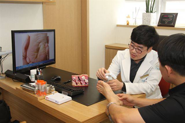 정홍대 피부과 전문의가 발바닥에 생긴 사마귀의 병변을 살펴보고 있다. 애플피부과 제공.