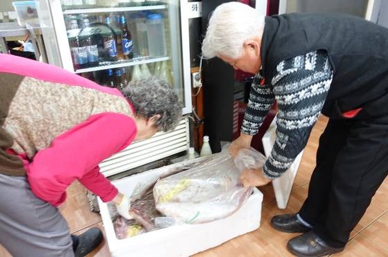 덕인집 주인 부부가 흑산도 홍어중매인이 보낸 홍어 포장을 풀고 있다. 10~12kg 암치 3마리가 들어있다.