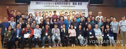 세계한인론인연합회와 재외동포언론인협의회 소속 회원들이 19일 충남 천안 국학원에서 임시총회를 열어 세계한인언론인협회로 통합할 것을 결의한 뒤 기념촬영을 하고 있다. [연합뉴스 자료 사진]