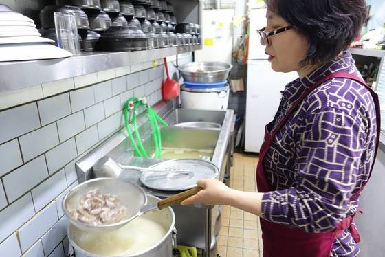 김미자씨가 끓고 있는 설렁탕 국물에 수육으로 나갈 고기를 데치고 있다.