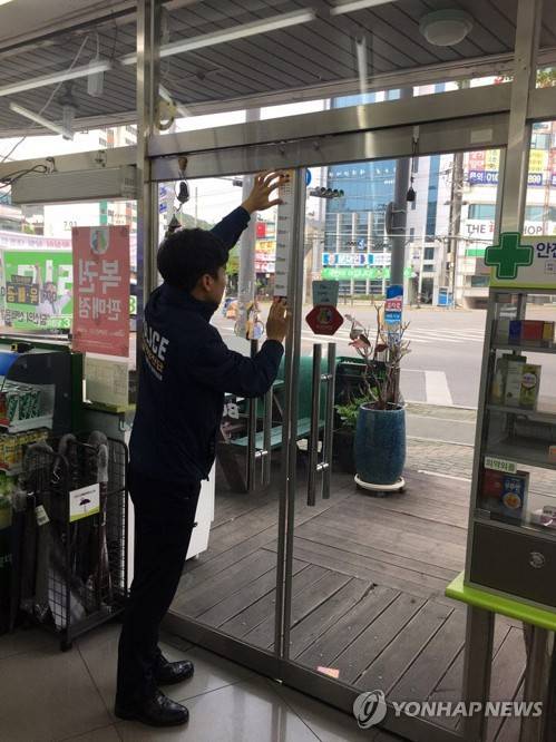 (구미=연합뉴스) 경북 구미경찰서가 21일 키재기 스티커를 제작해 한 편의점 문에 설치하고 있다. 폐쇄회로(CC)TV로 범죄자의 키를 쉽게 파악할 수 있다. 2017.4.21 [경북 구미경찰서 제공=연합뉴스]