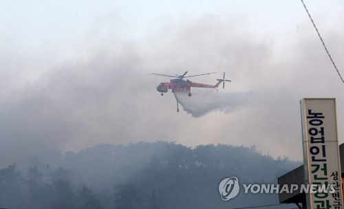 (강릉=연합뉴스) 유형재 기자 = 산림청 초대형 진화헬기가 7일 강원 강릉시 성산면에서 자욱한 연기 속에 물을 뿌리고 있다. 2017.5.7      yoo21@yna.co.kr